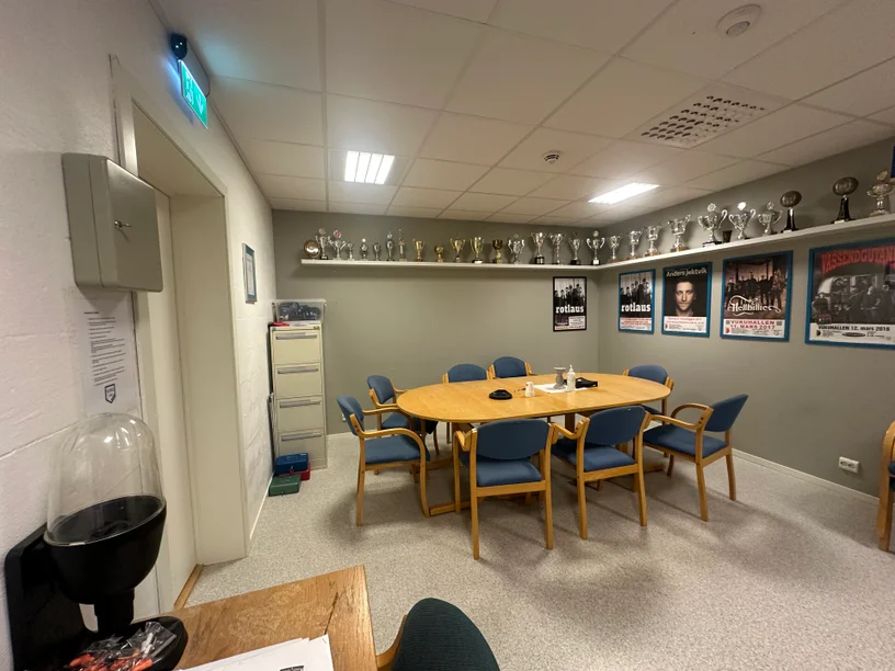 Møterommet i Vukuhallen med bord, stoler og pokaler