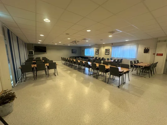 Sosialrommet i Vukuhallen med bord og stoler